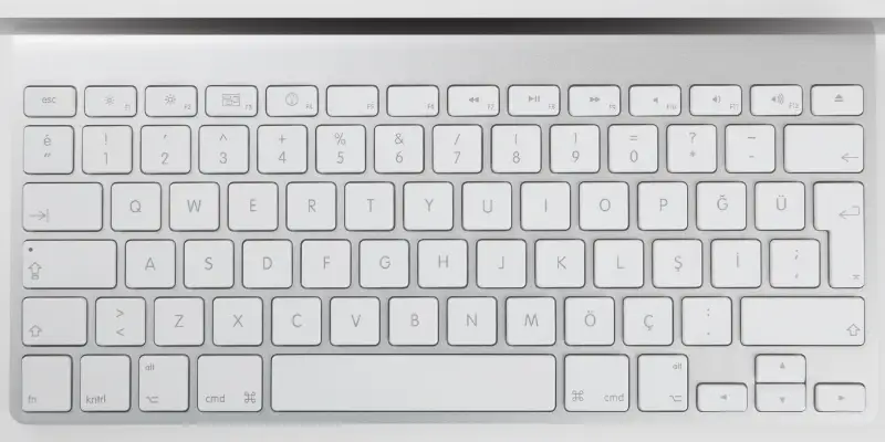 Clean white laptop keyboard with backlit keys
