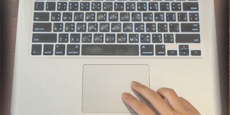 Close-up of a hand performing a two-finger scroll on a laptop
