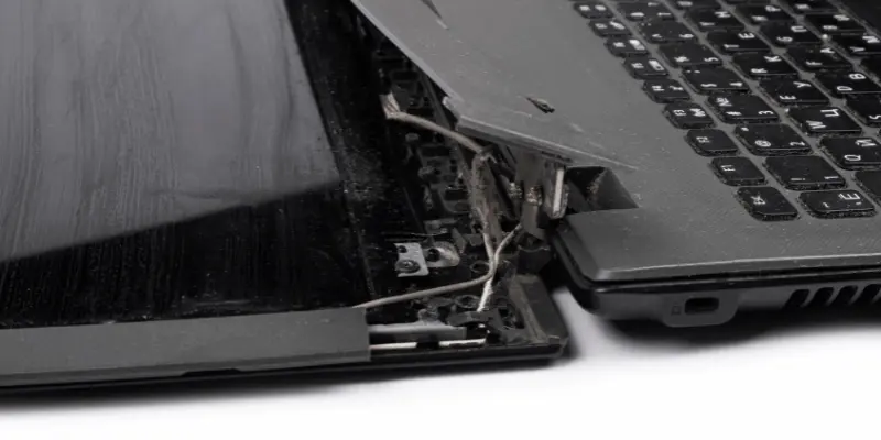 Broken laptop hinge showing damage and exposed wiring.