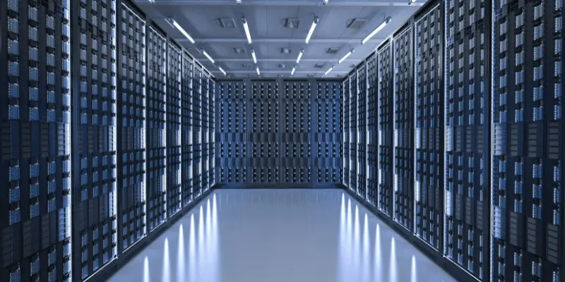Long corridor lined with towering server racks in modern data center with bright LED lighting