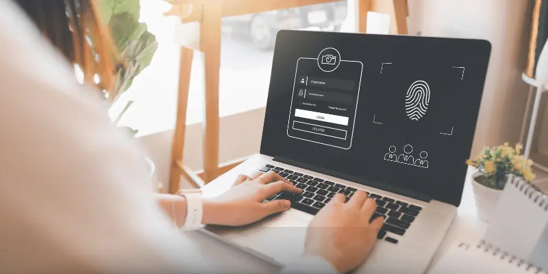 Laptop showing login interface with username, password, and fingerprint option
