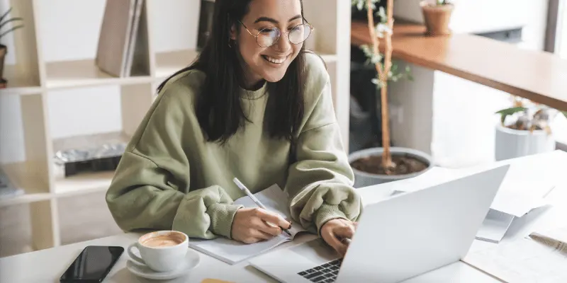 Businesswoman using laptop with icons representing digital tools