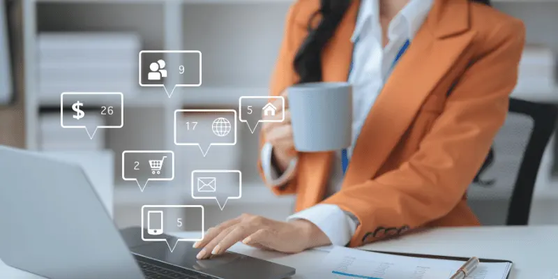 Woman handling online tasks with coffee and laptop